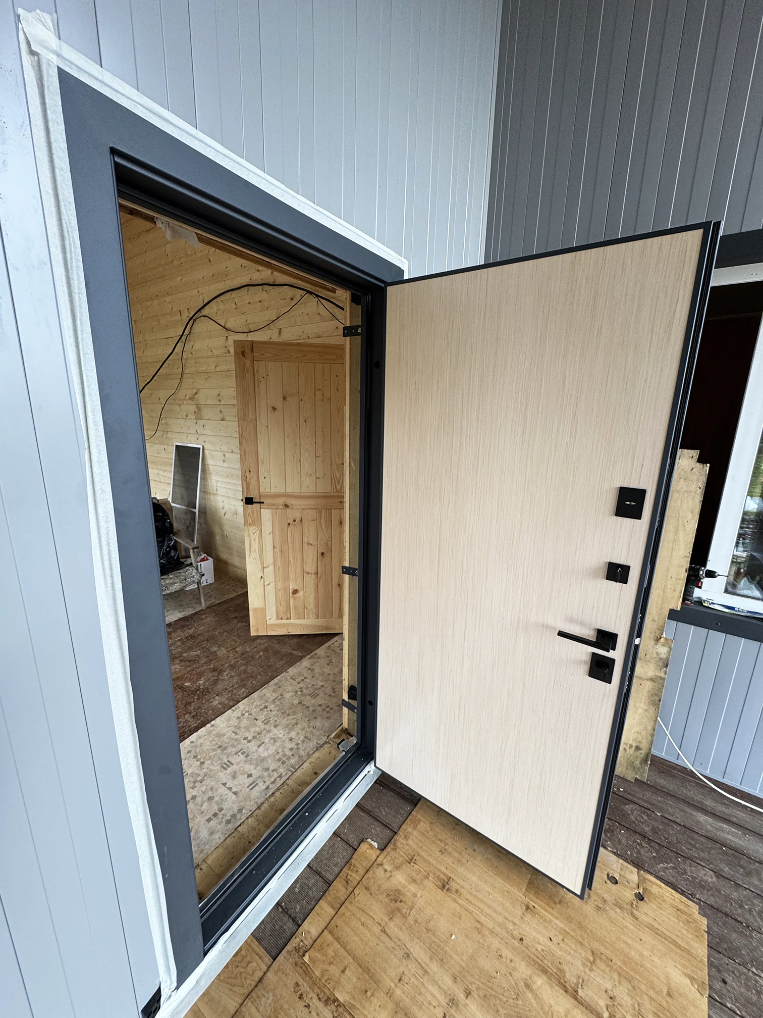 Входная дверь со светлым ламинатом для дачного дома